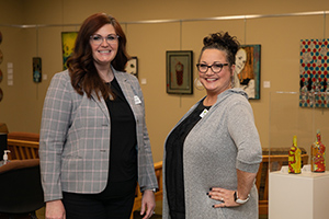 Director of Libraries Sharon Edwards, left, and Library Associate Jennifer Robinson stand in front of the new art display at Motlow’s Moore County campus library.
