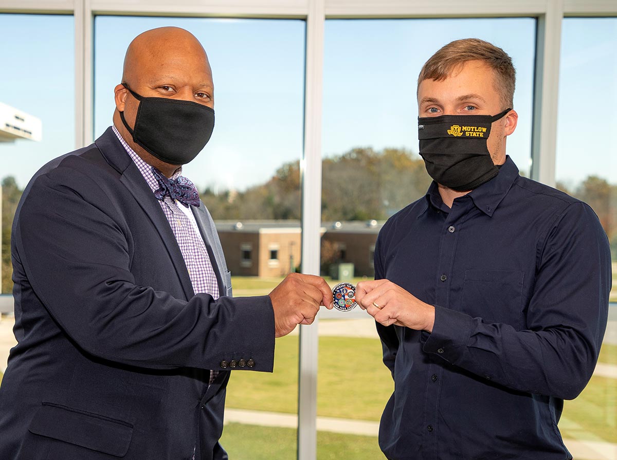 Motlow President Dr. Michael Torrence, left, awards Motlow freshman and U.S. Navy veteran Zachary Dwyer a special challenge coin, representing the inaugural TBR Chancellor’s Commendation for Military Veterans. 